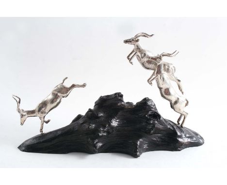 A CONTEMPORARY SOUTH AFRICAN MINIATURE SCULPTED GROUP OF THREE LEAPING IMPALA on an ebony base by Patrick Mavros of Zimbabwe,