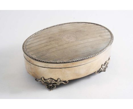 A LARGE OVAL DRESSING TABLE JEWELLERY BOX with an engine-turned cover & four openwork cast feet, by the Goldsmiths & Silversm