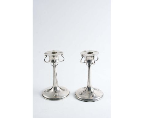 A PAIR OF EDWARDIAN ART NOUVEAU CANDLESTICKS on rising circular bases & waisted capitals with sinew-like buttresses, the deta