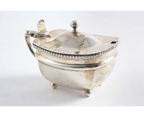 A GEORGE III MUSTARD POT on ball feet with a gadrooned border, low-domed cover & ball finial, the front with a vacant cartouc