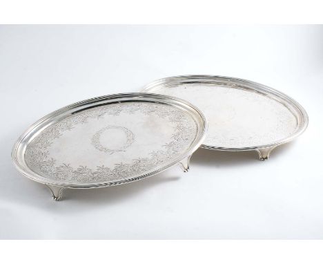 A PAIR OF GEORGE III ENGRAVED OVAL SALVERS with reeded borders, bracket feet and vacant wreath cartouches in the centre, flan