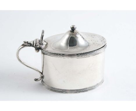 A GEORGE III OVAL MUSTARD POT with a scroll handle, reeded borders & a blue glass liner, the domed cover with a ball finial, 