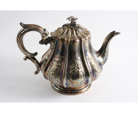 A VICTORIAN IRISH TEA POT with a fluted, pear-shaped body chased with floral sprays and two vacant cartouches, the cover with