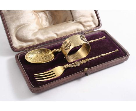 A SILVERGILT CHRISTENING SET including a "Coronation" spoon & fork and a napkin ring with applied shamrock, thistle, rose & r