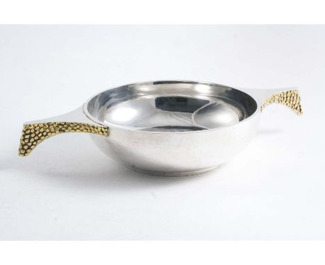 A CONTEMPORARY PARCELGILT QUAICH  with textured, down-turned handles and a collet foot, by Stuart Devlin, London 1972; 8"  (2
