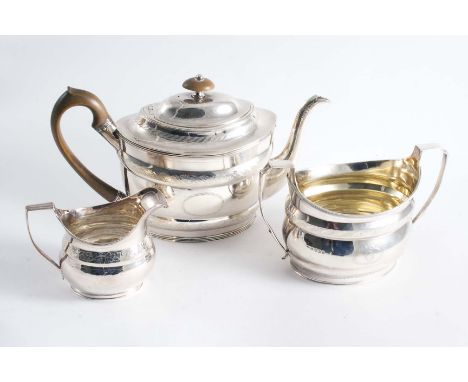 A GEORGE III COLLECTED OR MATCHED THREE-PIECE TEA SET including a navette-shaped tea pot with engraved borders & vacant carto