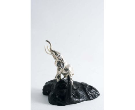 A CONTEMPORARY SOUTH AFRICAN MINIATURE SCULPTED FIGURE OF A BULL ELEPHANT with resin tusks, trumpeting, on an ebony base, by 