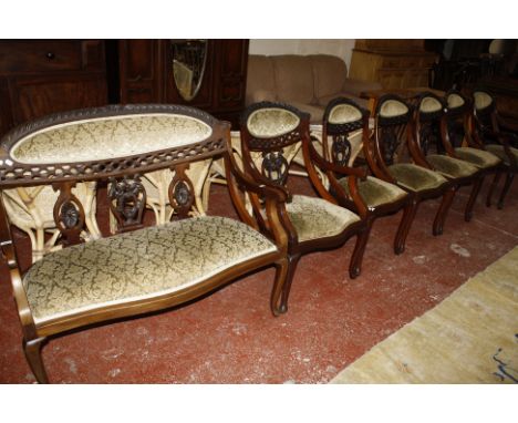 A set of six late Victorian mahogany drawing room chairs with upholstered seats and panel backs, pierced and carved back rail