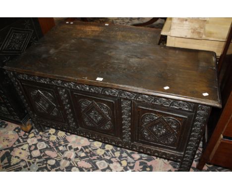 A late 17th century oak coffer with a triple carved panel front and carved stiles, 131cm 