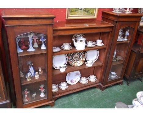 A Victorian mahogany low bookcase, moulded top with sunken centre above open shelves, flanked by a pair of glazed doors, skir