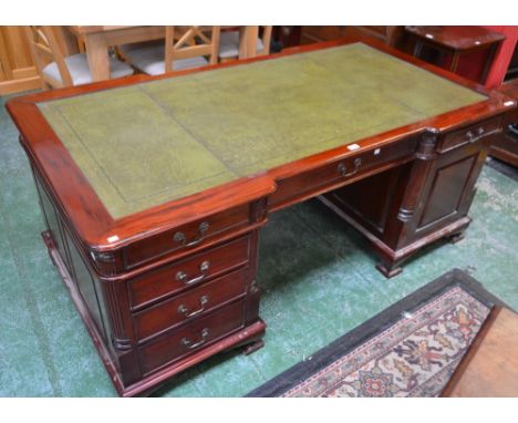 A George III Revival mahogany partner's desk, inverted breakfront rounded rectangular top with inset writing surface above si