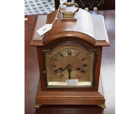 An oak bracket clock, silvered dial, Roman and Arabic numerals, 35cm high over handle