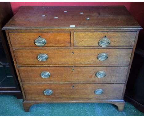 A George III oak chest of two short over three long graduated drawers, slightly oversailing moulded top, brass swing handles,