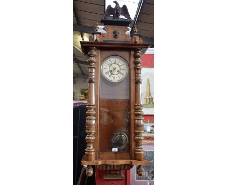An early 20th century Vienna wall clock, cream dial, Roman numerals, eagle finial, stained wooden glazed case