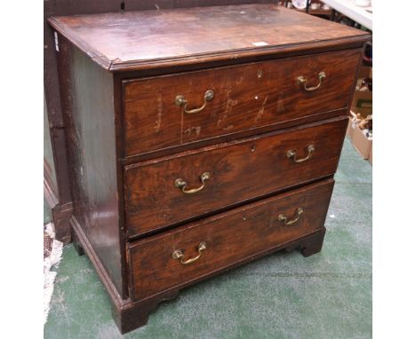 A George III mahogany chest of three long cockbeaded drawers, the top outlined with barber-pole stringing, brass swan neck ha