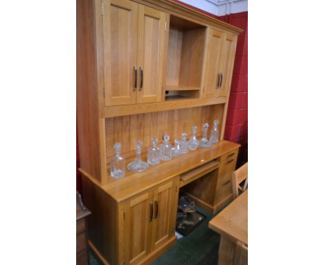 A contemporary light oak two-tier desk, outswept cornice above a central shelved niche flanked by a pair of panel doors each 