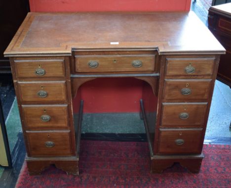 A 19th century mahogany kneehole desk, inverted break-centre top with inset tooled writing surface above an arrangement of dr