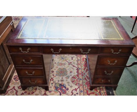 A mahogany twin pedestal writing desk, rectangular top with inset writing surface above three frieze drawers, further drawers