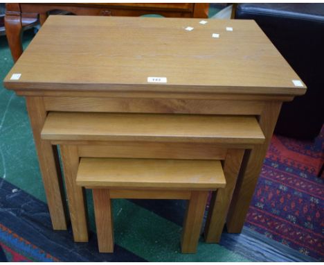 A contemporary light oak nest of three tables, the largest 60cm wide