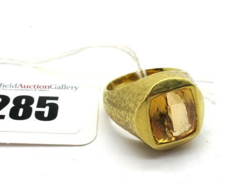 A Gent's Single Stone Ring, collet rubover set within textured tapering setting, stamped "750". 