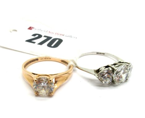 A Modern Single Stone Dress Ring, stamped "585"; together with a three stone dress ring, stamped "375". (2)