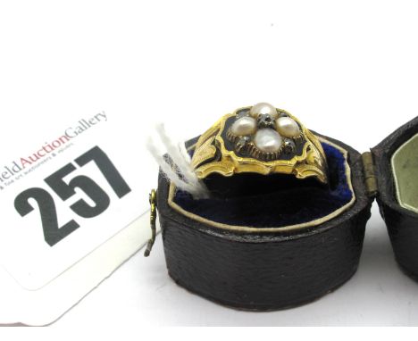 A XIX Century Pearl and Diamond Set Mourning Ring, highlighted in black enamel, between tapering textured shoulders, with gla