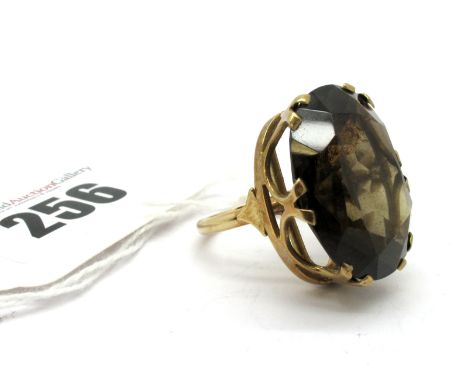 A 9ct Gold Smokey Quartz Single Stone Dress Ring, claw set high, on plain band. 