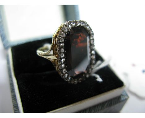 A Garnet and Diamond Set Panel Ring, of rectangular form with canted corners, the central panel within border of rose cut dia