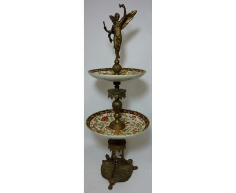 Two tier gilt metal and ceramic cake stand, surmounted by a figure of a Winged Victory H77cm  Condition Report Click here for