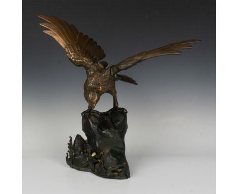 A magnificent bronze eagle, its wings outstretched, perched atop a sturdy metal black rock base. The bronze captures the intr