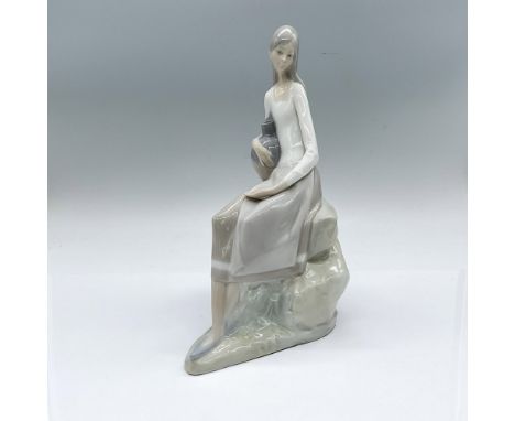 Glossy figure of a young woman sitting on a rock with her arm wrapped around a jug. Nao impressed stamp. Dimensions: 7"L x 5"