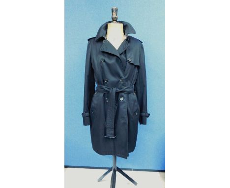 A lady's black Aquascutum trenchcoat, the double breasted coat with belted/tie waist, custom Aquascutum London buttons, side 