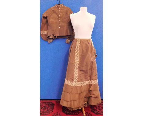 A Victorian lady's brown silk blouse and matching skirt, the blouse with pin detailing to front and sleeves with high neck wi