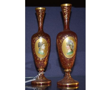 A pair of Victorian cranberry glass and enamel vases, the enamel plaques depicting soldiers, possibly Romans, within gilt fol