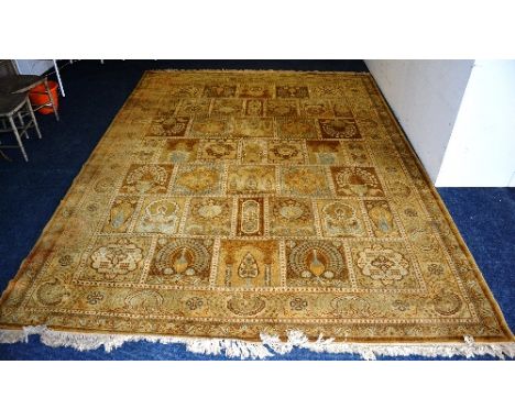 A large yellow carpet, with foliate squared patterns allover in browns, yellows and pale blues, 373cm x 275cm