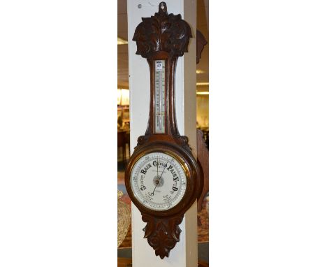 An Edwardian carved oak aneroid banjo barometer by James Ballantyne & Son Glasgow, with thermometer gauge and white enamel di