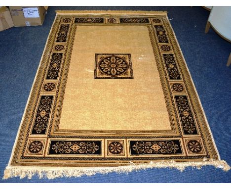 A Turkish machine made carpet, the central foliate square on cream ground, with black and red foliate border, 230cm x 160cm