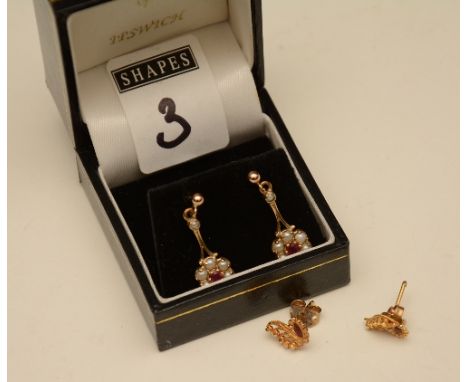 A pair of 9ct gold ruby and seed pearl flowerhead drop earrings, the central round cut ruby flanked by 6 seed pearls, stamped
