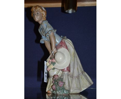 A Lladro matt glazed figure of a girl holding hat, 31cm high