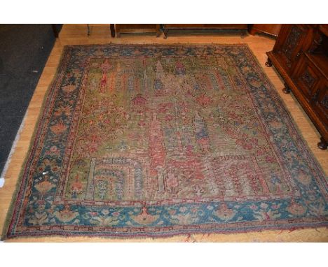 An Eastern carpet, decorated with tree and floral motifs in reds, beiges and blues on green ground, with blue floral border, 