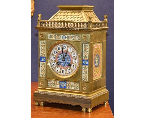 A brass mantel clock circa early 20th century, with enamel dial and panels, decorated with masks and floral panels, 30cm high