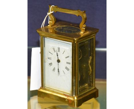 A brass carriage clock, with white enamel dial and carry handle, 16cm high