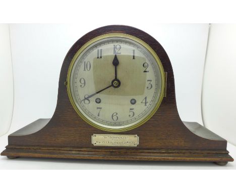 An oak mantel clock with striking movement, the movement marked Empire, Made in England, inscription on front