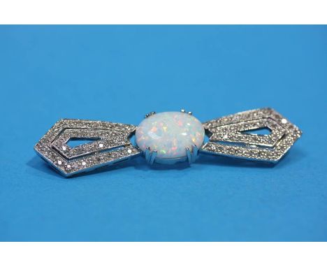 An 18ct white gold bow brooch set with central opal and flanked by diamond