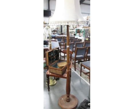 A tall wooden standard lamp and shade