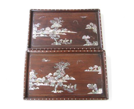 A pair of Chinese mother-of-pearl inlaid hardwood trays, each depicting a mounted figure with attendants travelling through a