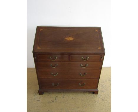 A Sheraton revival period reproduction George III inlaid mahogany fall front bureau, the fall decorated with inlaid bat's win