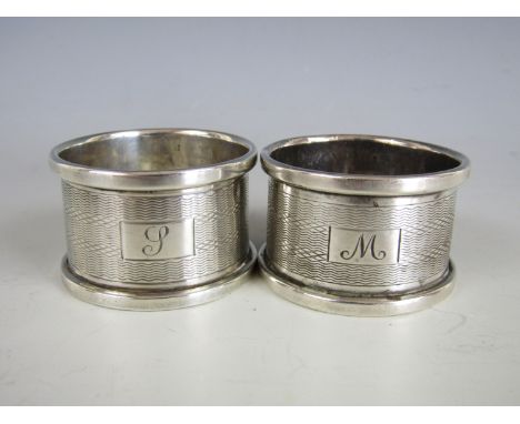 A pair of silver napkin rings, bearing engine-turned decoration and cartouches with engraved initials, Lanson Ltd, Birmingham