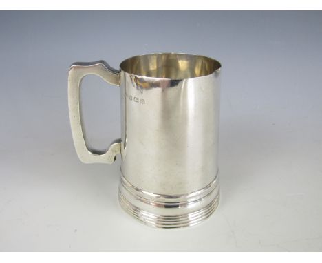 A pair of George V silver tankards, each of tapering cylindrical form with banded decoration and a shaped bracket handle, eng