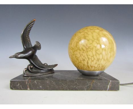 An Art Deco figural table lamp, with spherical glass shade decorated with dappled yellow spots, and a bronzed figure of a fly